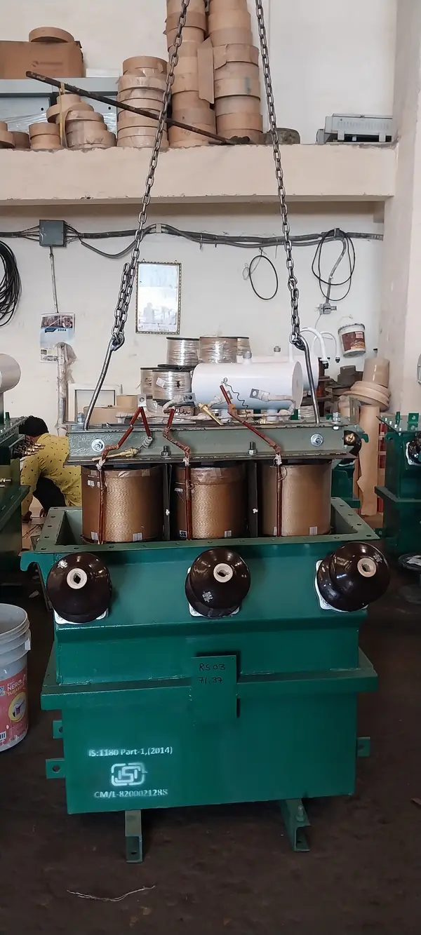Core and coil active part being lowered into a distribution transformer tank