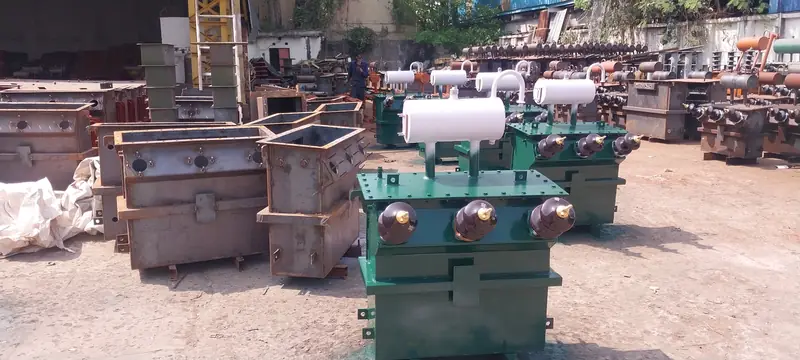 Fabricated transformer tanks and a finished distribution transformer in the Dynamech yard