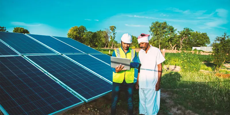 Engineer and farmer reviewing a solar water pumping installation under the PM-KUSUM scheme